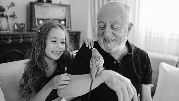 grandfather holding bird with granddaughter