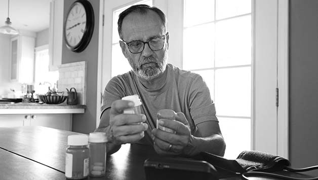 older man reading diabetes pills label