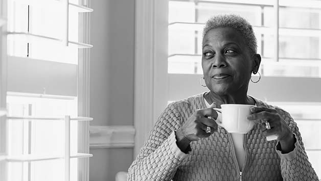 woman drinking tea by window