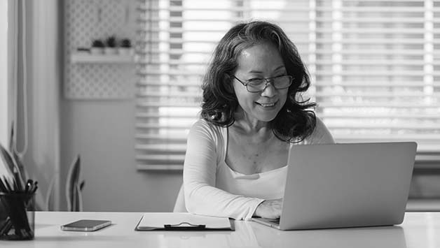 thai senior woman typing on laptop