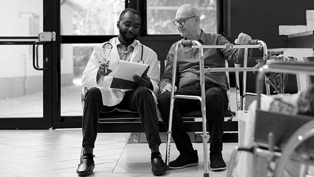 doctor assessing senior man mobility with walker