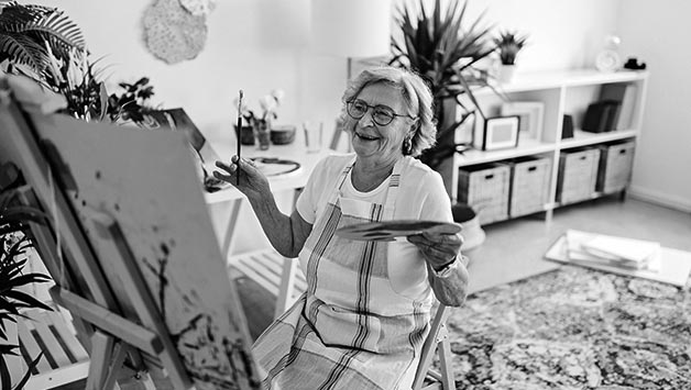 senior woman painting canvas
