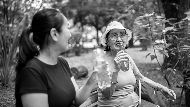 two senior women taking water break from heat